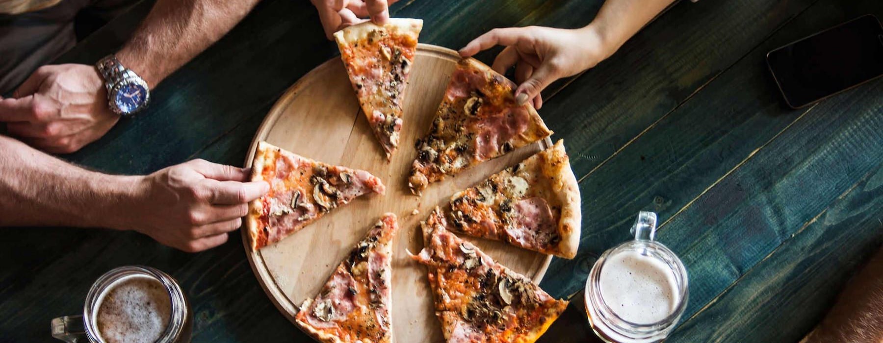 a group of people eating pizza